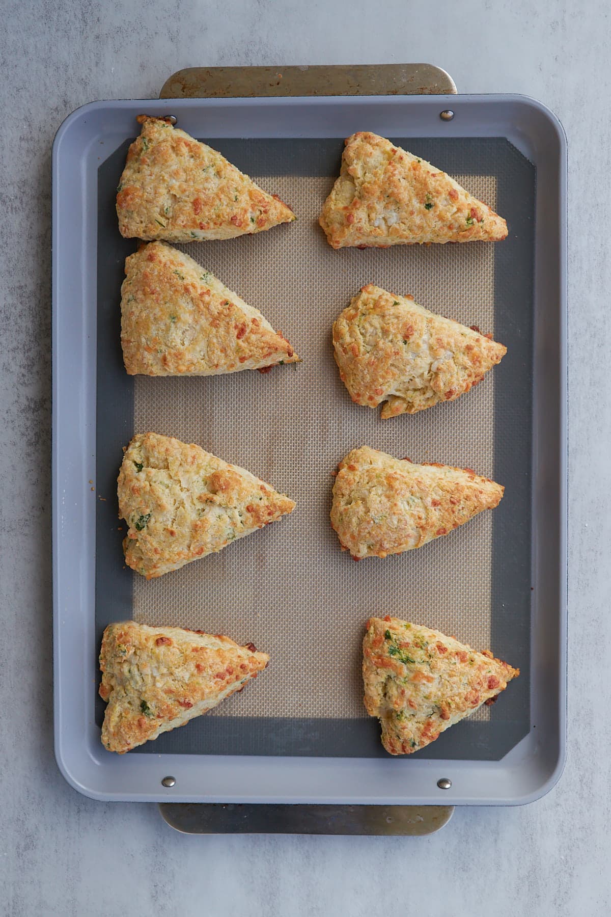 8 garlic scone wedged on a baking sheet post bake.