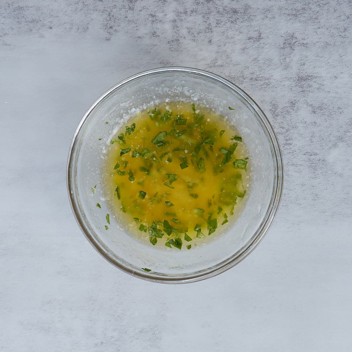 small bowl of melted butter, parsley, and garlic powder.