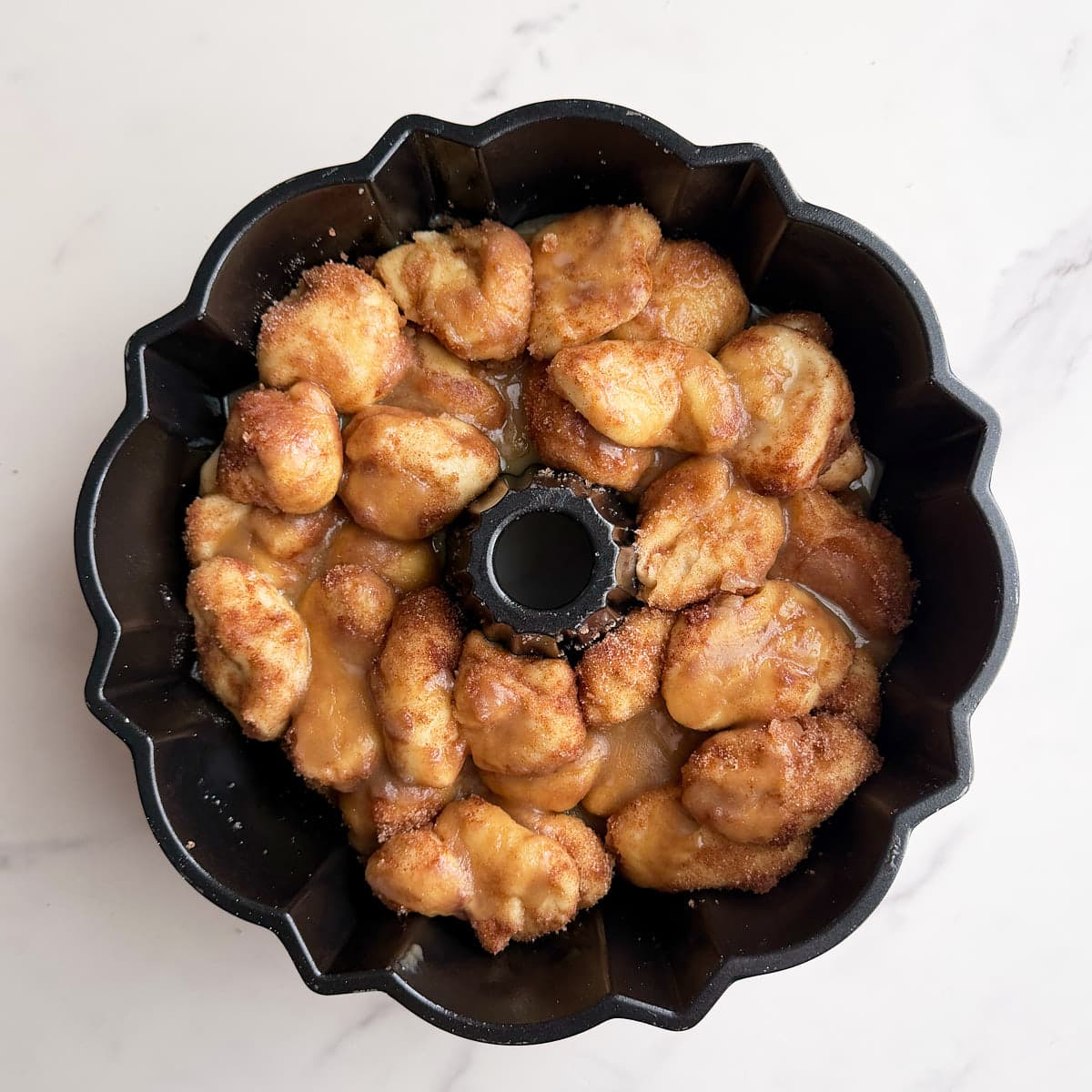 A second layer of sourdough monkey bread in the bundt pan, coated with brown sugar butter mixture.