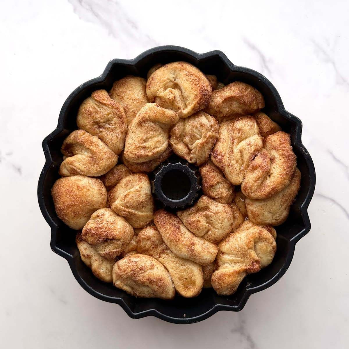 Sourdough monkey bread prepared in a greased bundt pan ready to bake.