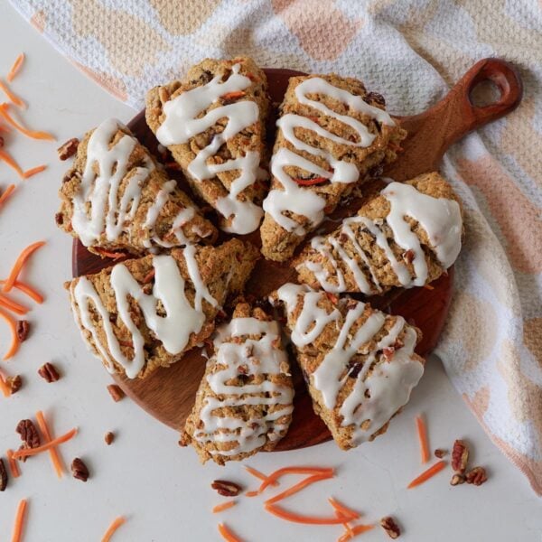 7 Sourdough Carrot Cake Scones arranged in a circle on a round wooden board.
