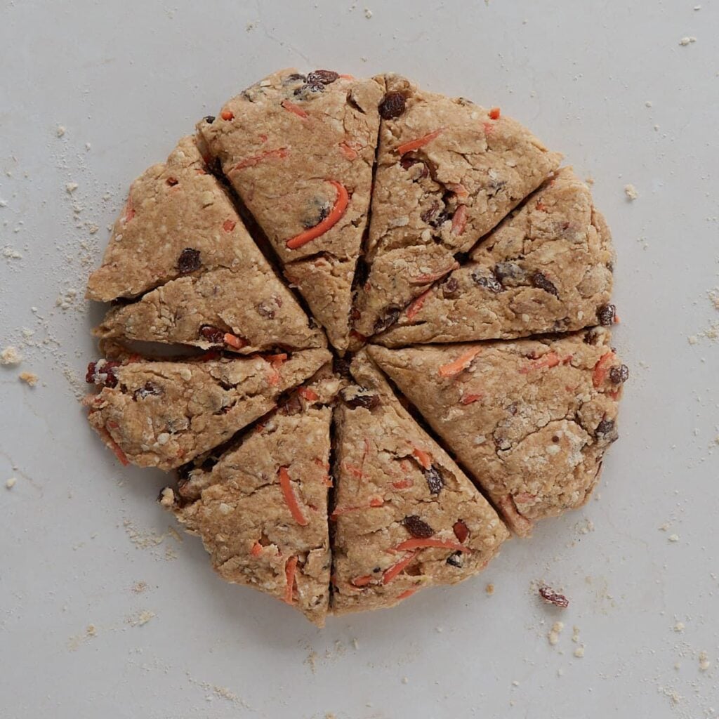 Sourdough Carrot Cake Scones shaped in a circle cut into 8 pieces.