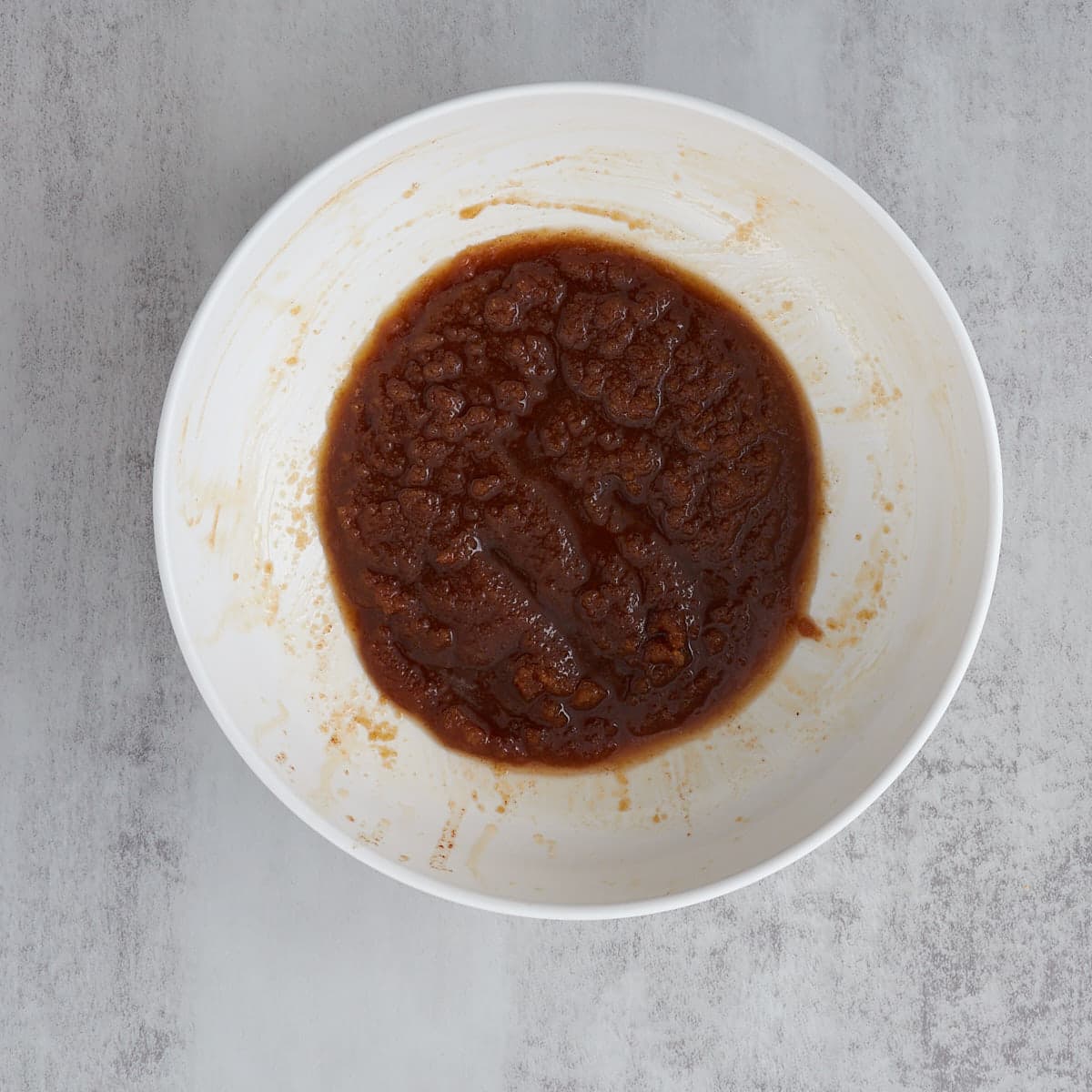 A white bowl of brown butter and brown sugar combined in a large mixing bowl.