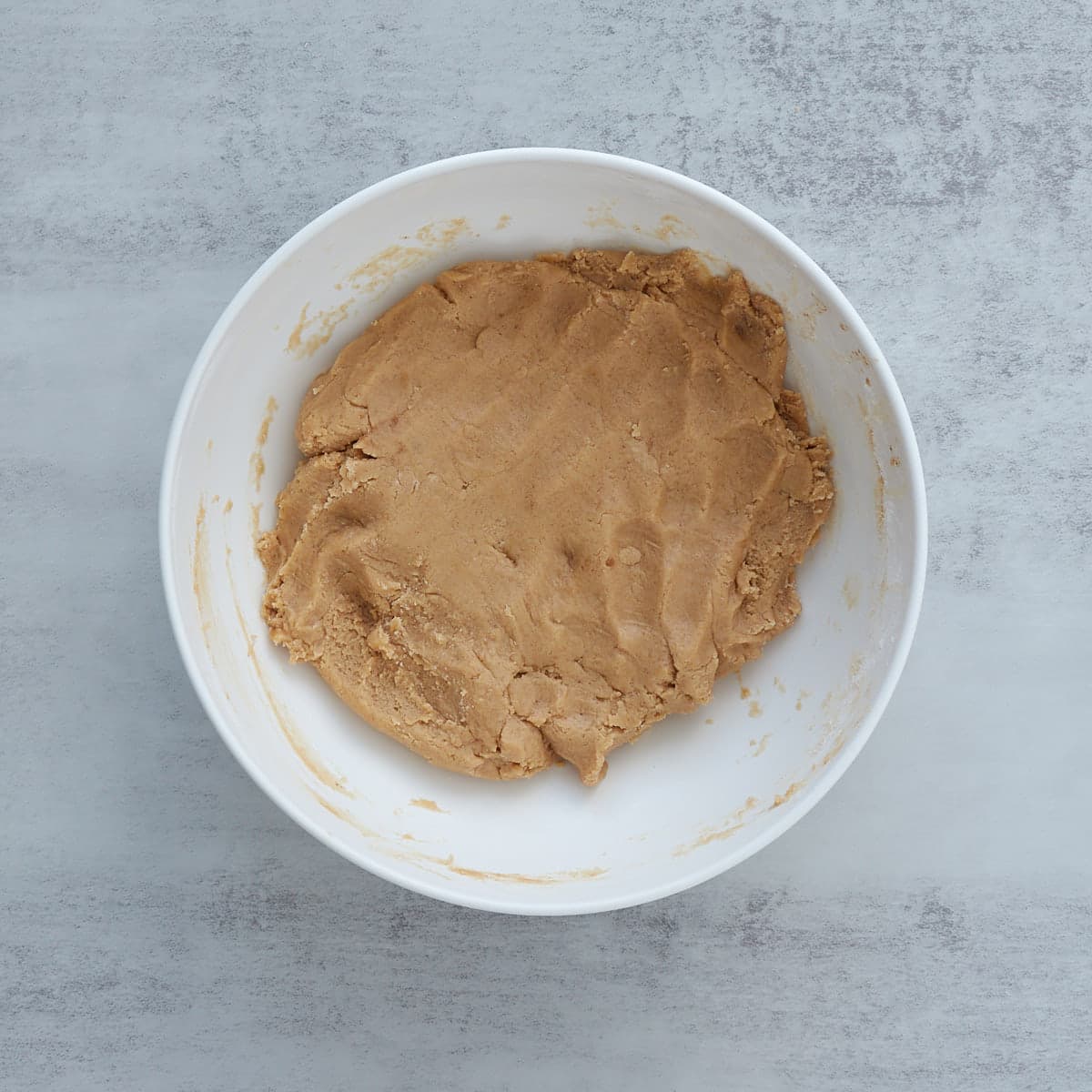 Dry ingredients added to the sourdough cinnamon roll cookie dough in a large mixing bowl.