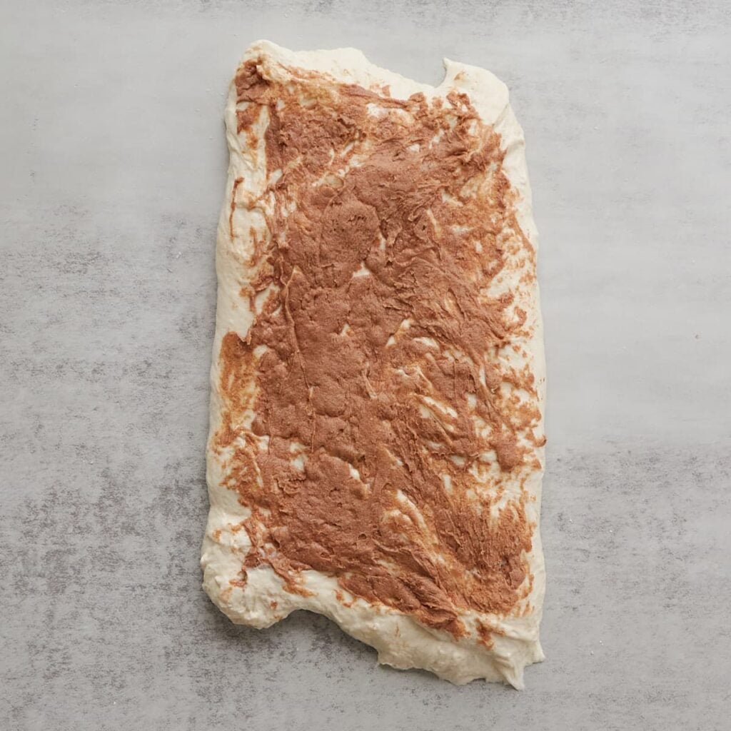 Cinnamon honey butter spread on sourdough bread dough.