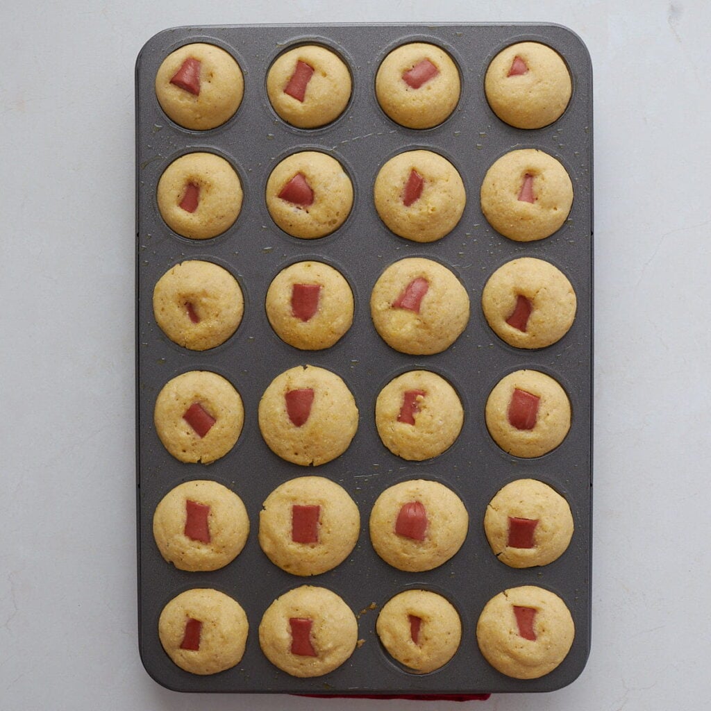 Freshly baked sourdough mini corn dogs in a mini muffin pan.