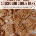 Sliced Cadbury Egg Sourdough Cookie bars on brown parchment paper with Cadbury mini eggs scattered around.