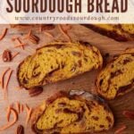 Slices of Carrot Cake Sourdough Bread on a wooden surface with shredded carrots and pecans scattered around.