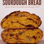 Carrot Cake Sourdough Bread cut in half and stacked on top of each other on a wooden surface.