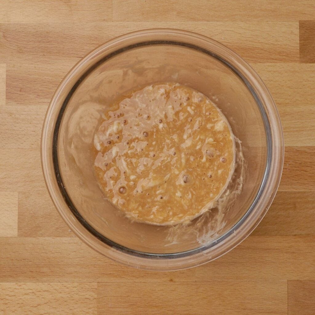 Wet ingredients mixed in a clear bowl for sourdough animal crackers.