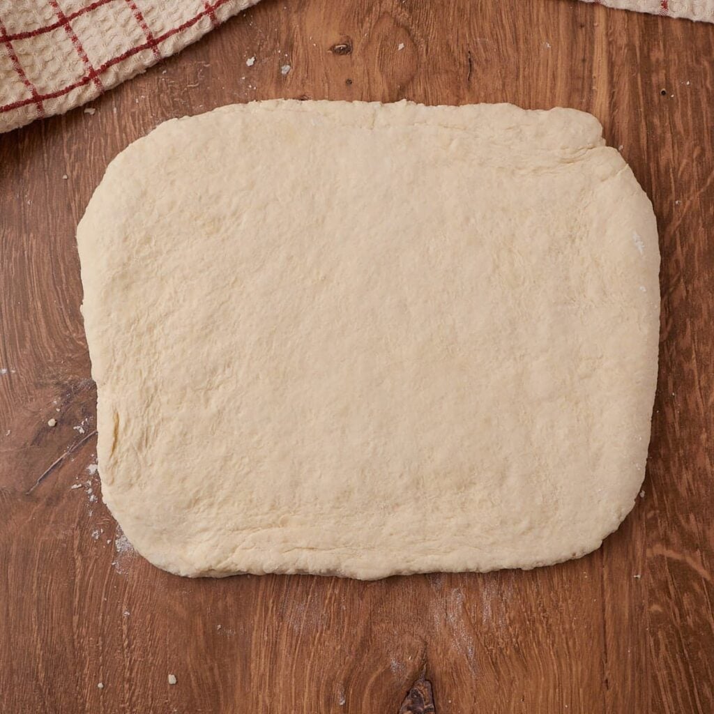 Dough for Sourdough Buttermilk Biscuits rolled into a rectangle before cutting.