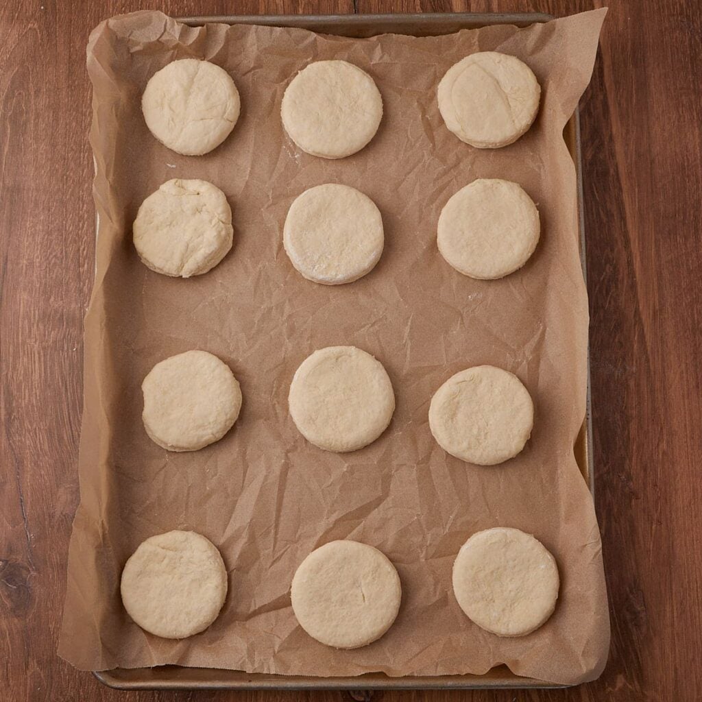 Sourdough Buttermilk Biscuit dough on a sheet pan lined with parchment paper before baking.
