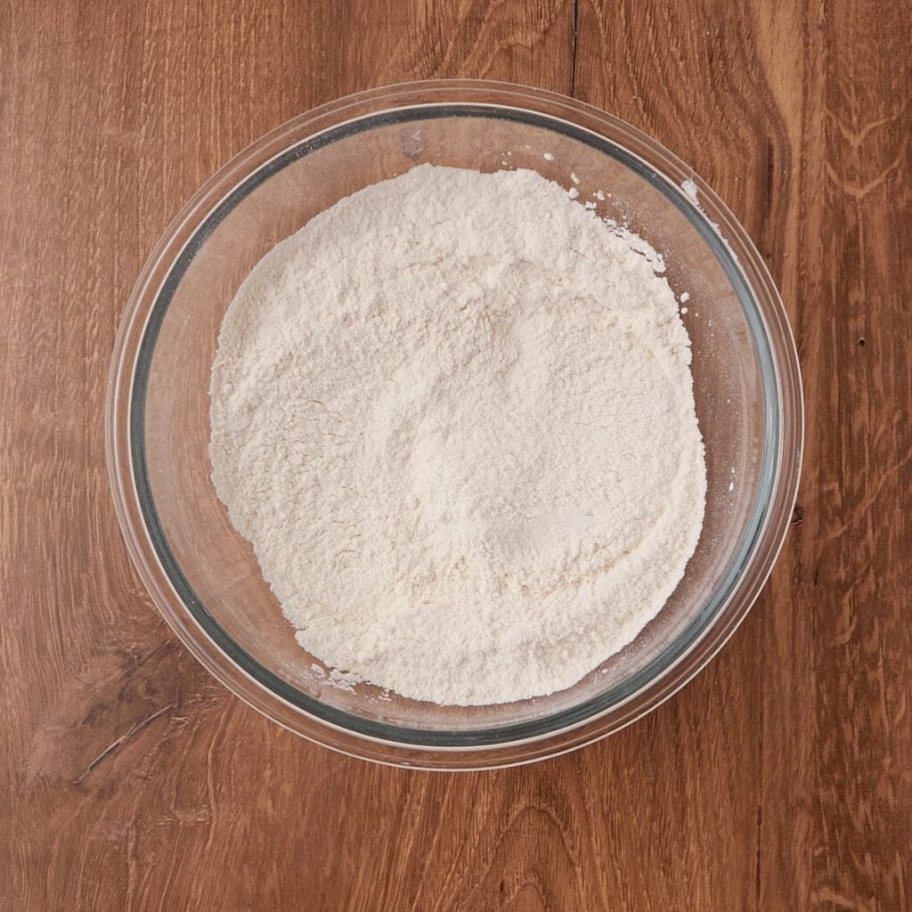 Dry ingredients mixed together in a clear bowl for sourdough buttermilk biscuits.