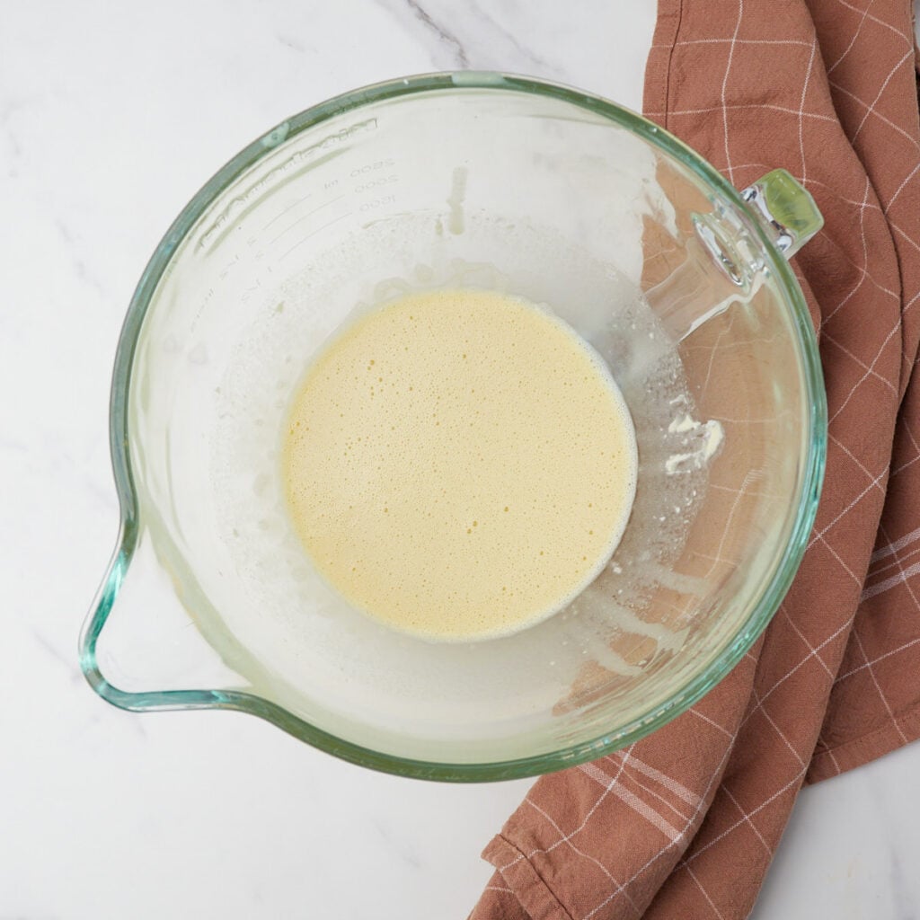 Wet ingredients added to the eggs for Sourdough Carrot Cake in a clear bowl.