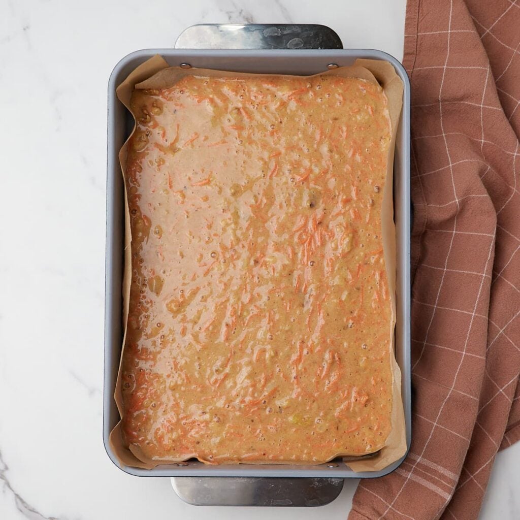 Sourdough Carrot Cake batter poured in a parchment lined 9x13 pan.