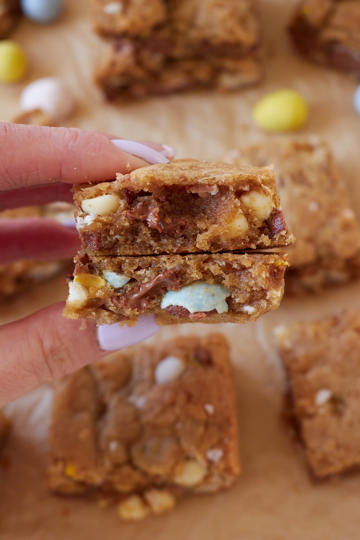 A hand holding a Cadbury Egg Sourdough Cookie Bar broken in half.
