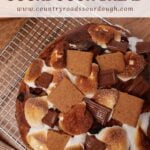 S'mores Sourdough Bread with toasted marshmallows, chocolate squares, and chunks of graham crackers on top.