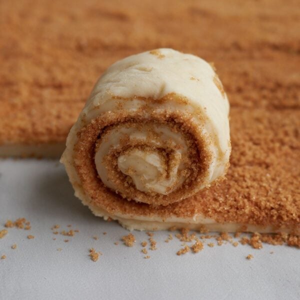 Rolling up the sourdough cinnamon roll dough after adding the filling.