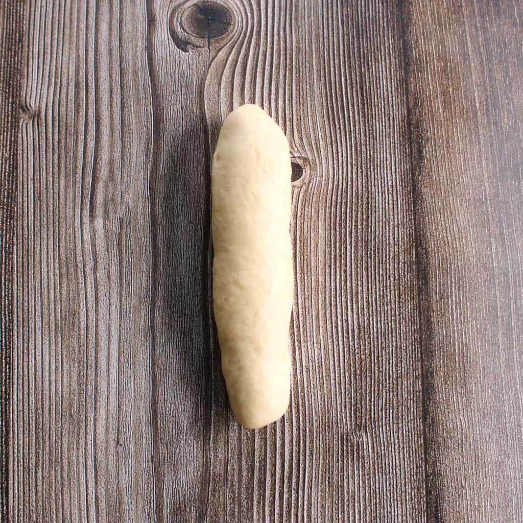 Dough for sourdough discard hot dog buns shaped into a log.