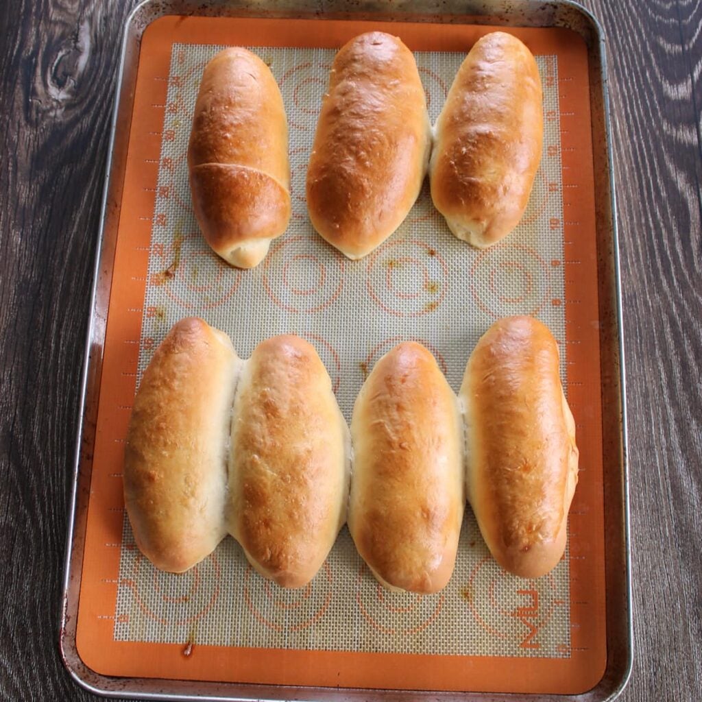 Sourdough discard hoy dog buns freshly baked on a sheet pan.