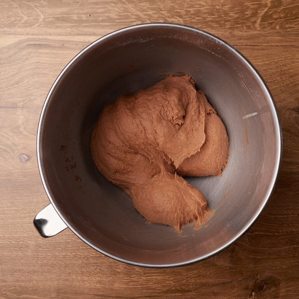 Dough for Cookies and Cream Sourdough Chocolate Rolls in the bowl of a stand mixer.