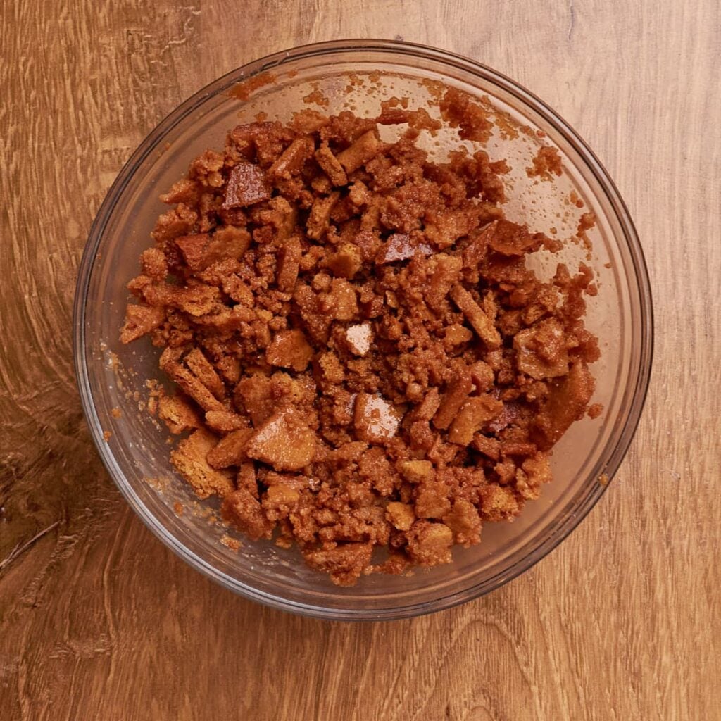 Butter and crushed graham crackers in a small, clear bowl.