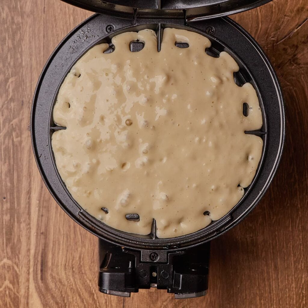 Sourdough waffle batter added to a waffle iron.