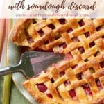 Sourdough Strawberry Rhubarb Pie with a slice taken out a pie server in the pan.