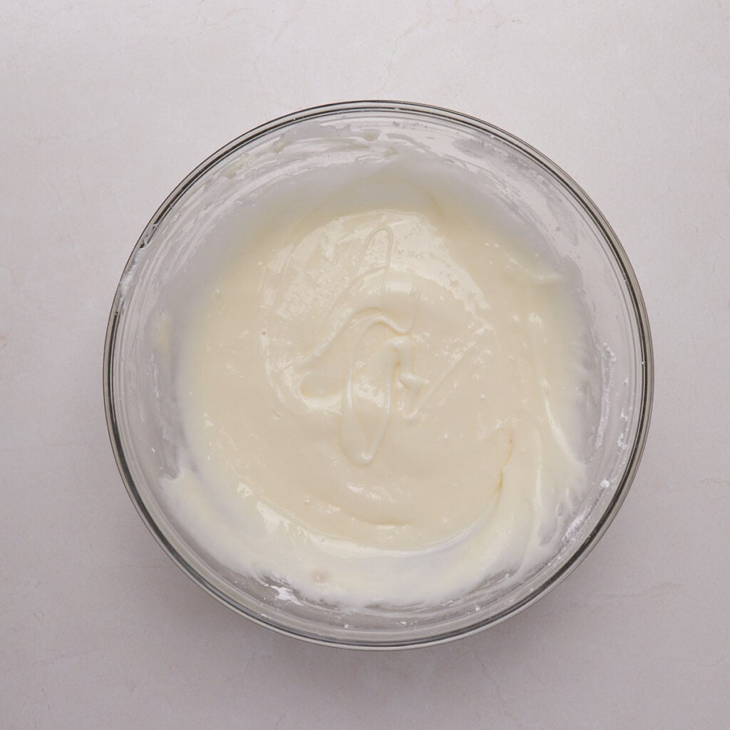 Lemon cream cheese frosting in a clear bowl.