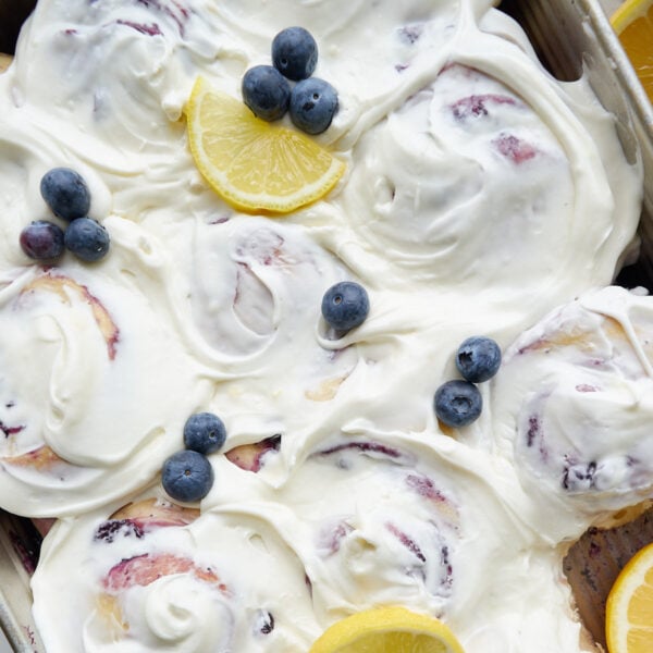 Lemon Blueberry Sourdough Rolls in a 9x13 pan with lemon cream cheese frosting and lemon slices and blueberries on top.