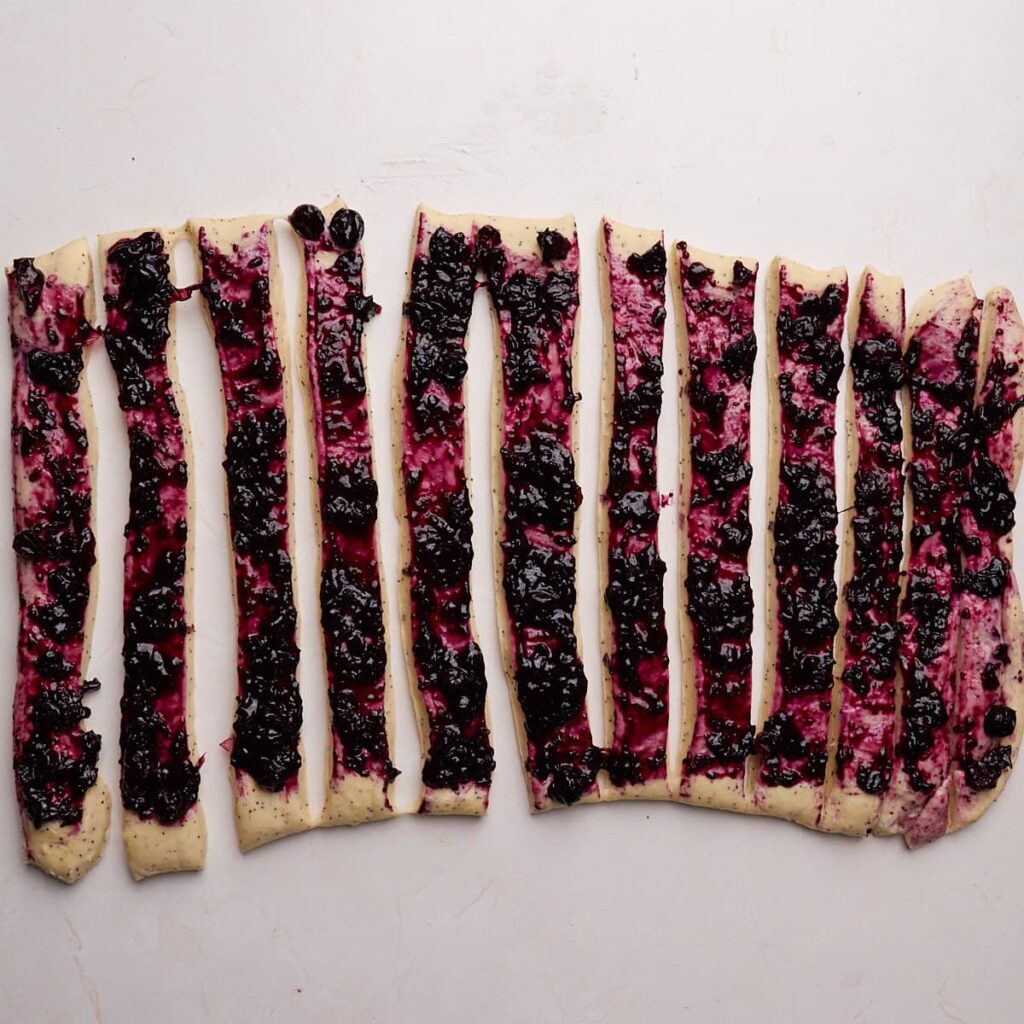 12 strips cut into the dough to make Lemon Blueberry Sourdough Rolls.