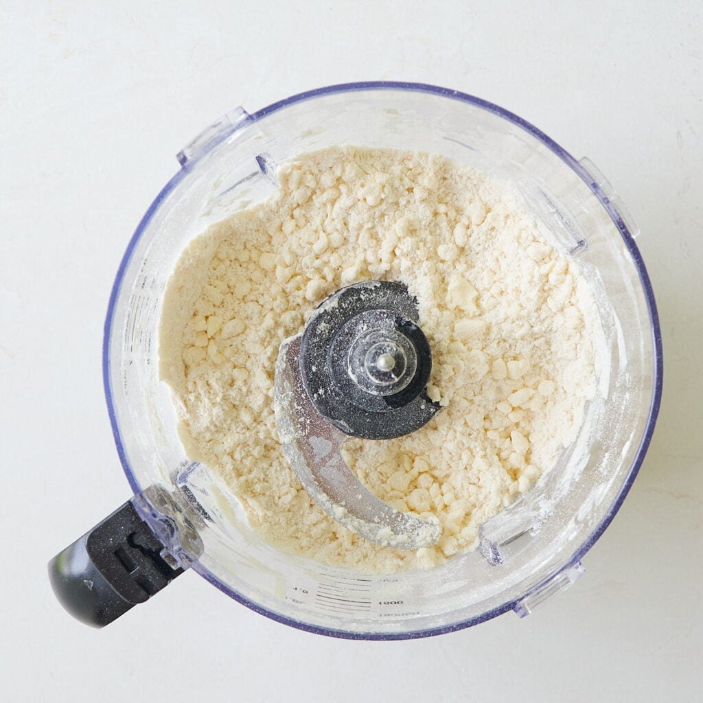 Butter added to the dry ingredients in a food processor for sourdough discard pie dough.