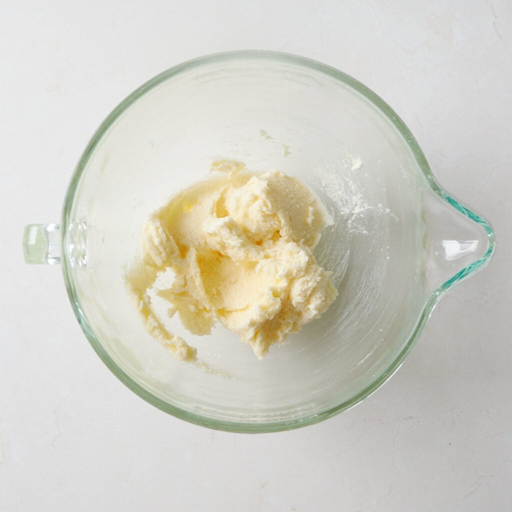 Butter and sugar creamed together in a clear bowl for Sourdough Sprinkle Cookies.