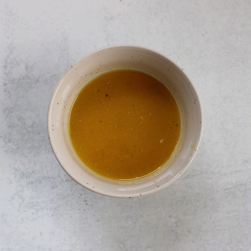 Melted butter with ranch seasoning mixed together in a small bowl.