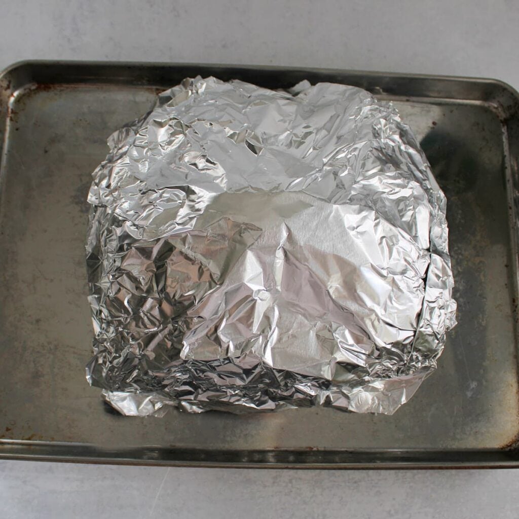 Jalapeno Cheddar Bacon Pull Apart Bread wrapped in foil on a sheet pan.