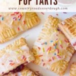 Sourdough Pop Tarts with Icing and sprinkles on a white background with sprinkles scattered around.