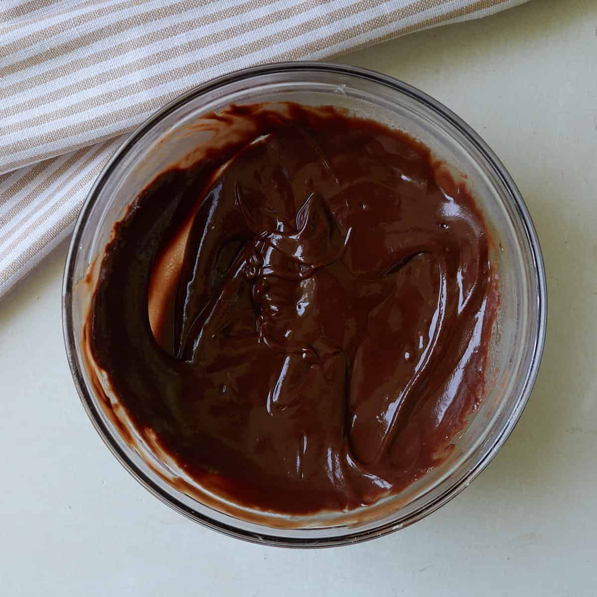 Chocolate chips and butter combined and melted in a clear bowl.