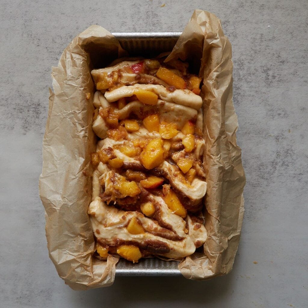 Sourdough Peach Pull-Apart Bread in a loaf pan lined with parchment paper before the first rise.
