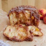 Sourdough Peach Pull-Apart Bread on brown parchment paper with a piece pulled off.