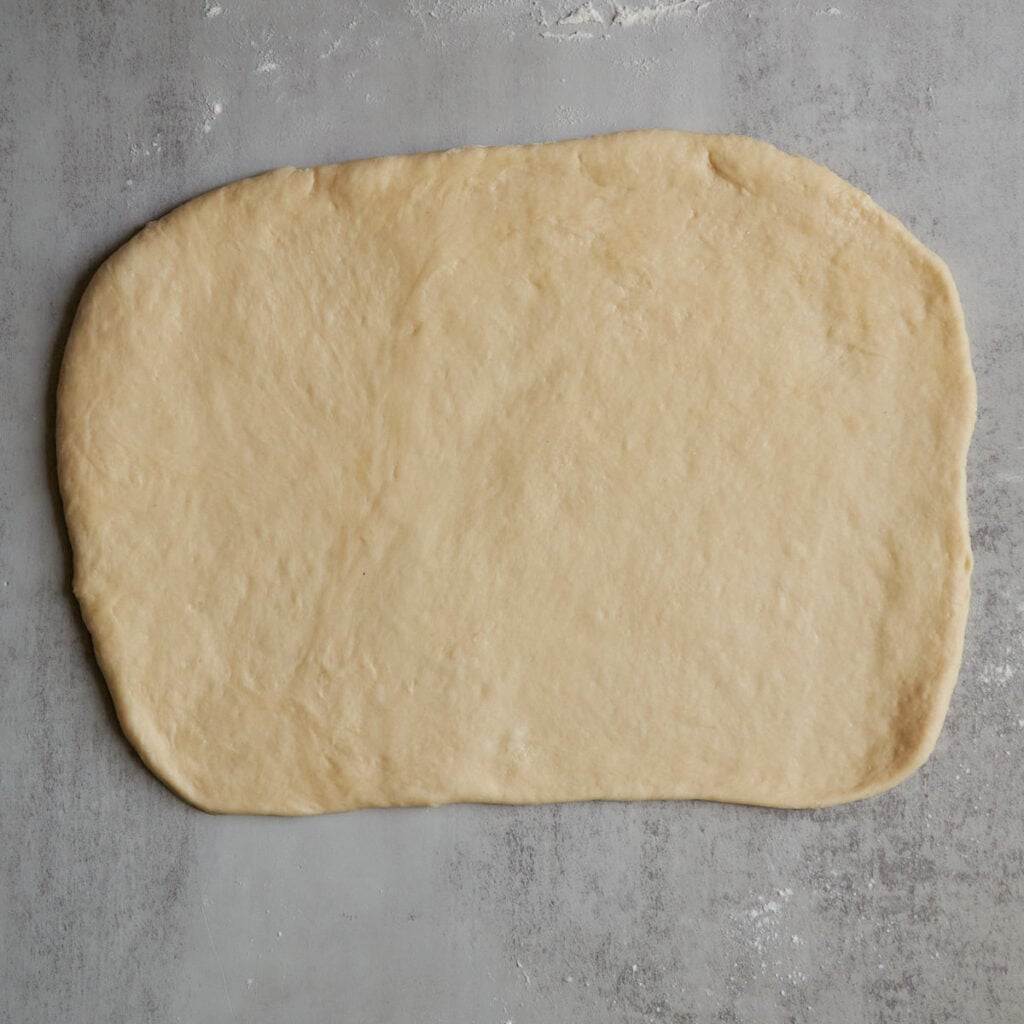 Dough for Sourdough Peach Pull-Apart Bread rolled into a rectangle.