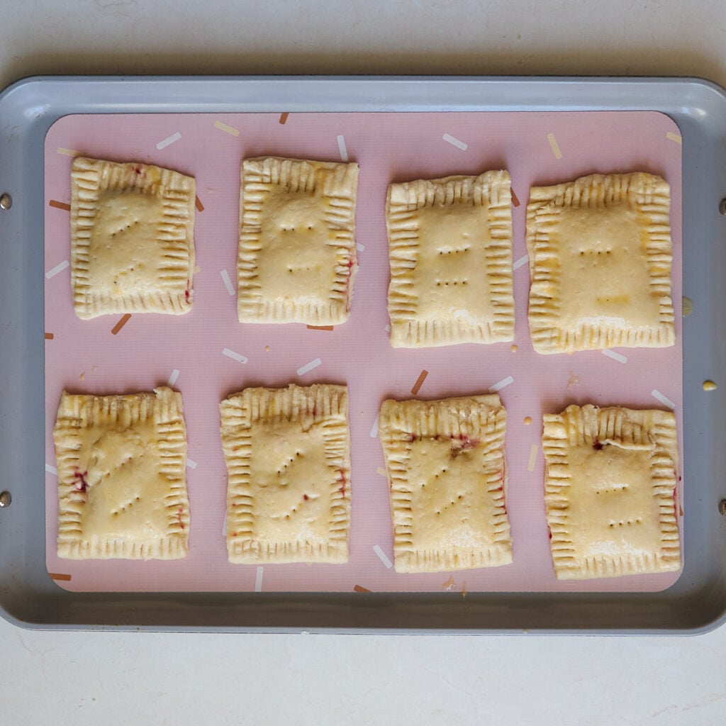 Egg wash added to Sourdough Pop Tarts on a baking tray lined with a silicone mat.