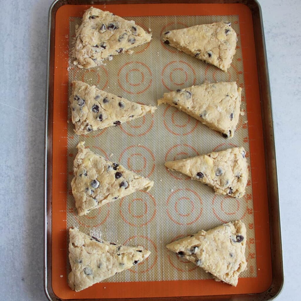 Unbaked Chocolate Chip Sourdough Scone on a silicone mat on a sheet pan.