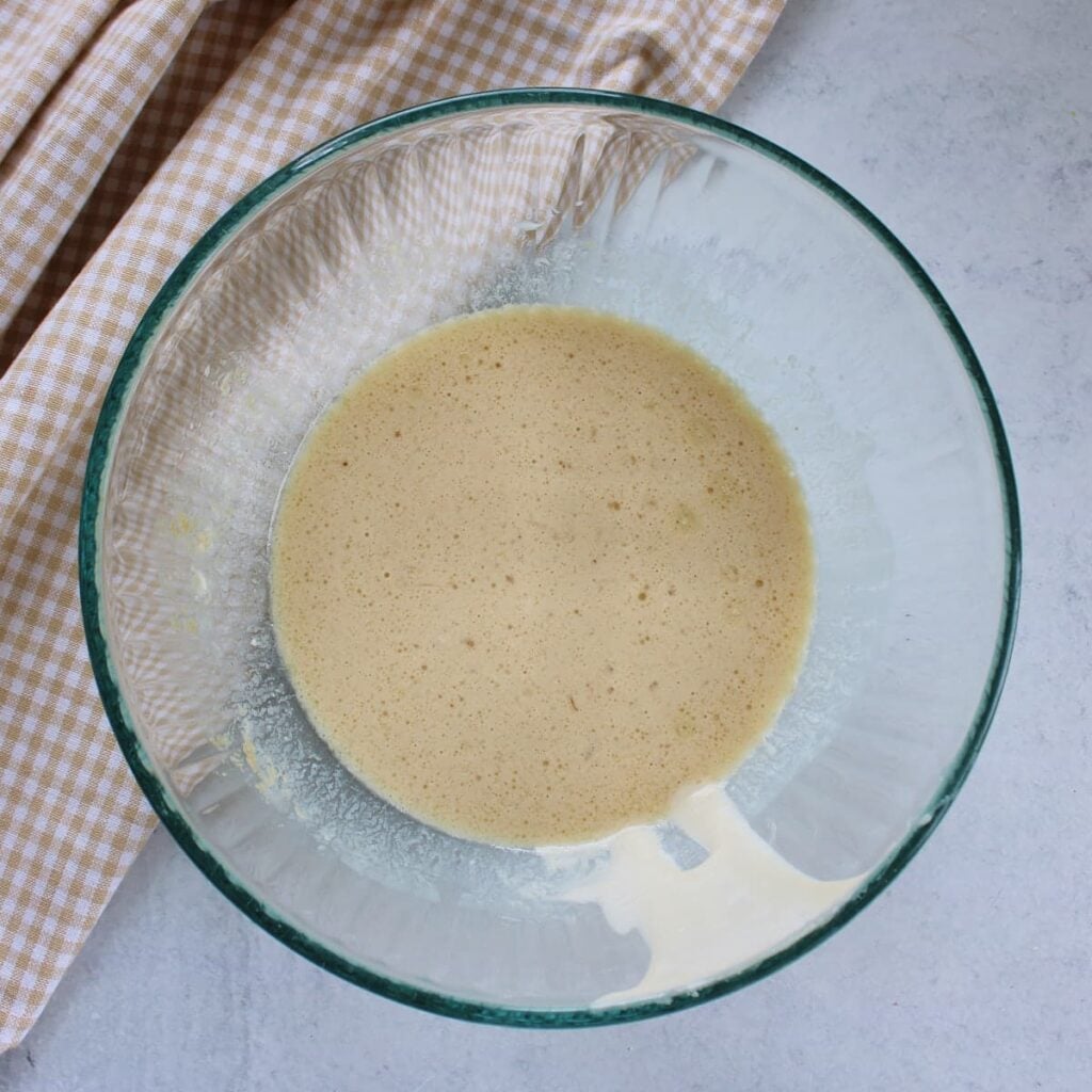 Wet ingredients for sourdough discard donuts in a clear bowl.