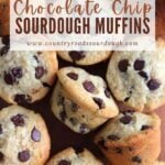 Chocolate Chip Sourdough Muffins on a wooden cutting board next to a white cloth napkin.