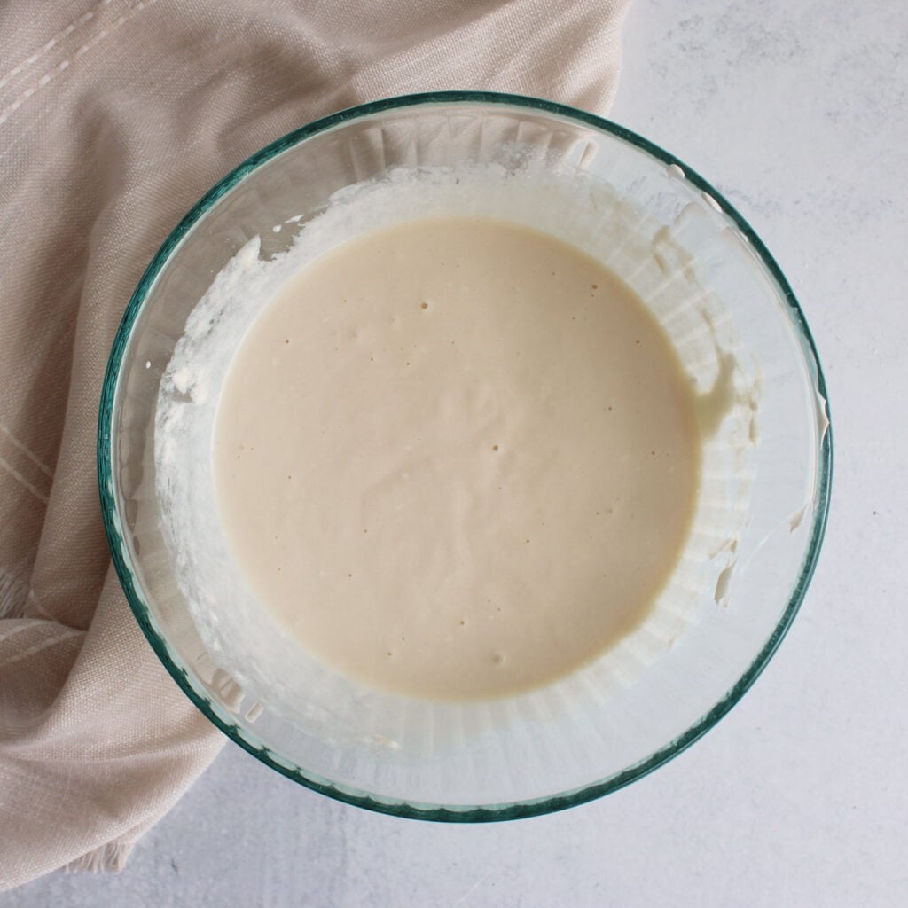 Wet ingredients for Chocolate Chip Sourdough Muffins in a clear bowl.