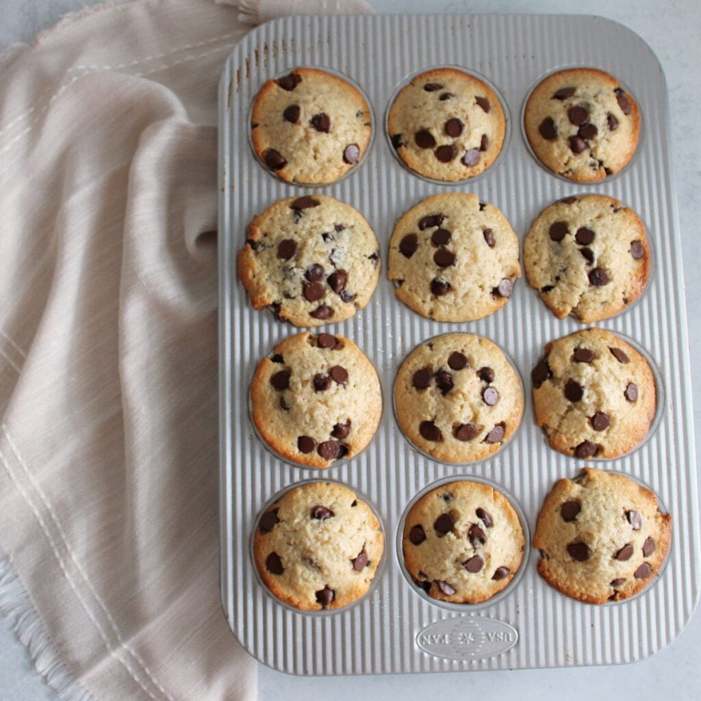Chocolate Chip Sourdough Muffins freshly baked in a muffin pan.