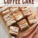 Sourdough Pumpkin Coffee Cake sliced into squares on parchment paper with a wooden handle serving spatula.