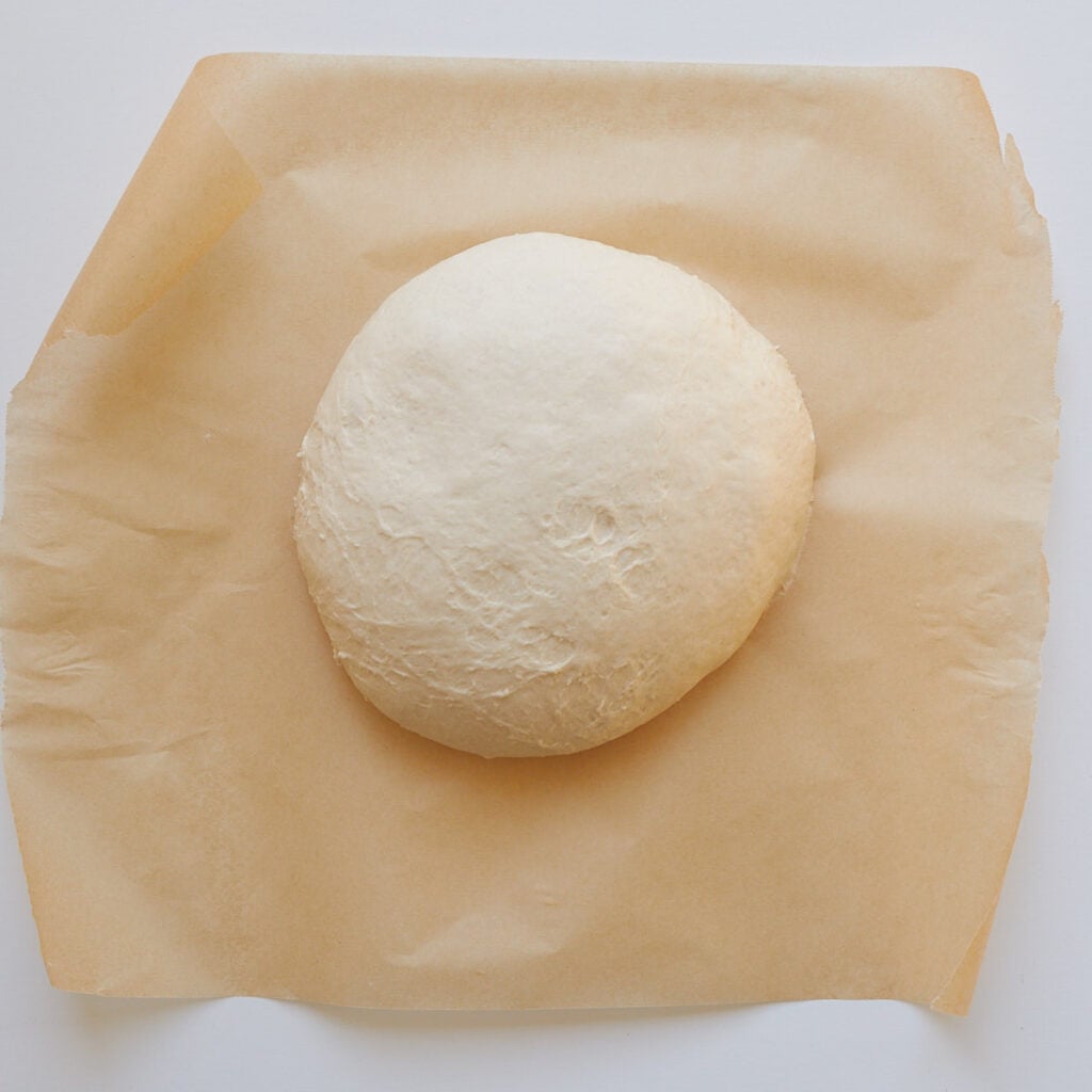 Sourdough discard bread shaped and placed on parchment paper.