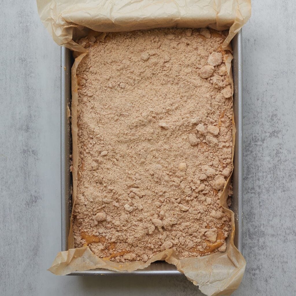 Batter and streusel added to parchment lined 9x13 pan.