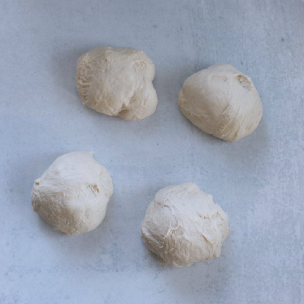 Sourdough mini bread loaves dough divided into 4 equal pieces.